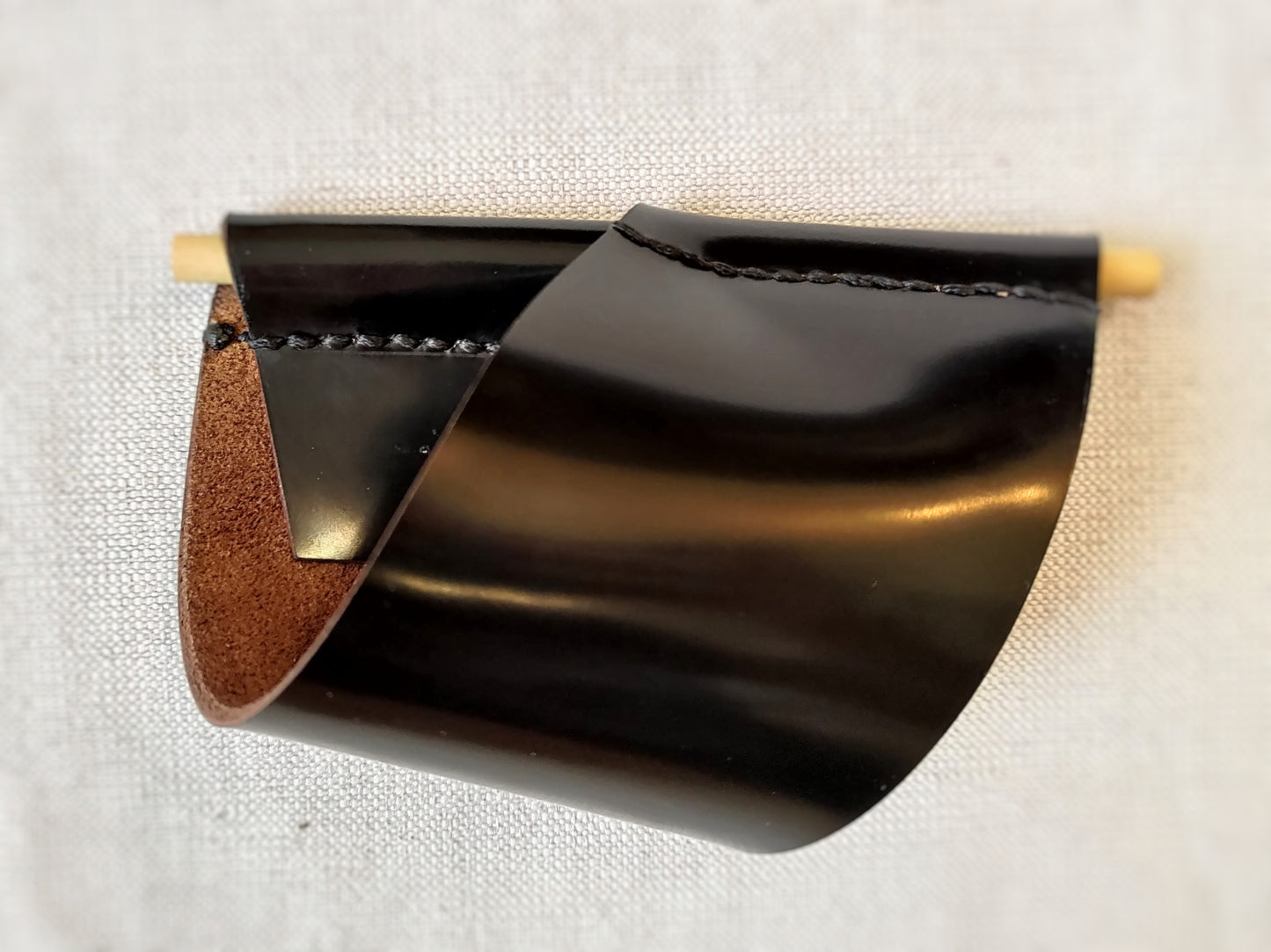 Black leather cuff with wooden pin closure